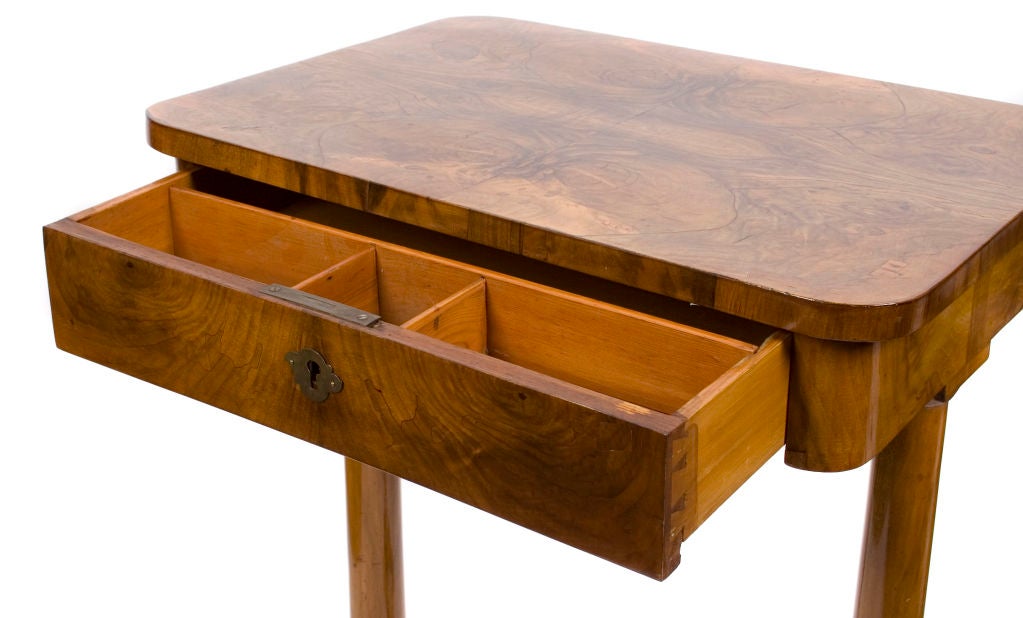 An Austrian Biedermeier walnut wood sewing table with a frieze drawer, supported by two columnar legs and stretcher on downswept feet, early 1800s.