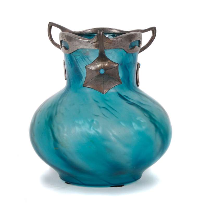 An Art Nouveau period glass vase with pewter mount. Glass, in the style of Loetz, is slightly frosted brilliant turquoise. Swirled metal mount, which is enhanced with turquoise glass cabochons, is marked ISIS 754, indicating that it was created by