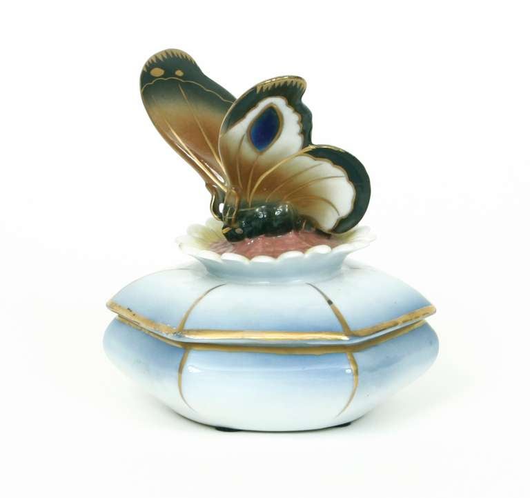 Charming hand-painted German Sitzendorf porcelain trinket box, circa 1940. Lid of faceted box features butterfly perched on sunflower in relief. Sitzendorf mark (which was used from 1902-1954) on bottom.
