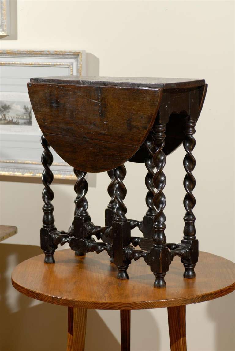 This is a gorgeous English barley twist drop leaf table c. 1820's. When the table is opened the top is oval and the barley twist legs swing out to support the top.  The table is very well made and the twists that are adjacent to each other spiral in