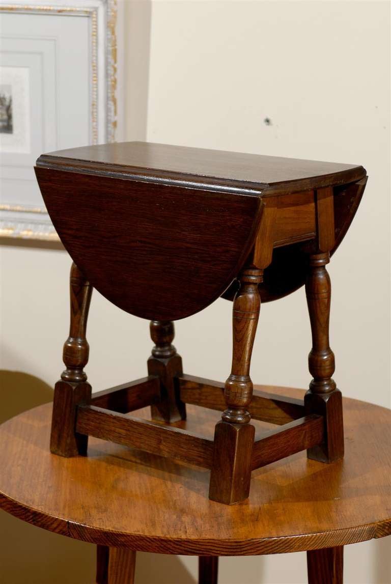 This is a beautiful swivel top drop leaf English table from 1900.  The legs are turned and splayed with stretchers.  To use as a larger table the leaves are to be lifted then twisted to stay up.

Dimensions:
Dropped table top- 18.75 x 10.25
Oval