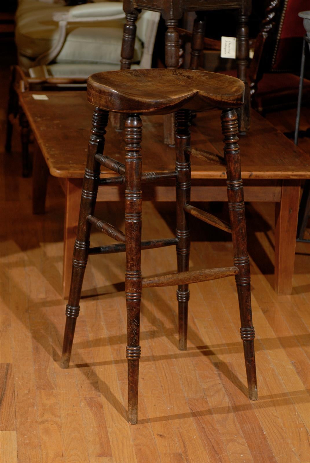 This stool has a lovely saddle shaped seat that is most comfortable. It is tall enough for a kitchen bar. The stool would look great in a room with a bar or a kitchen.