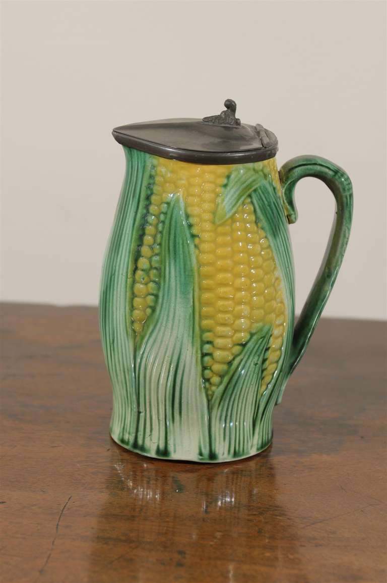 This is a lovely English majolica corn pitcher with a lid.  English majolica became popular in the 1850's.  Minton had featured some at the Chrystal Palace Exhibition in 1851.  Corn was first brought to England from the United States and was a very