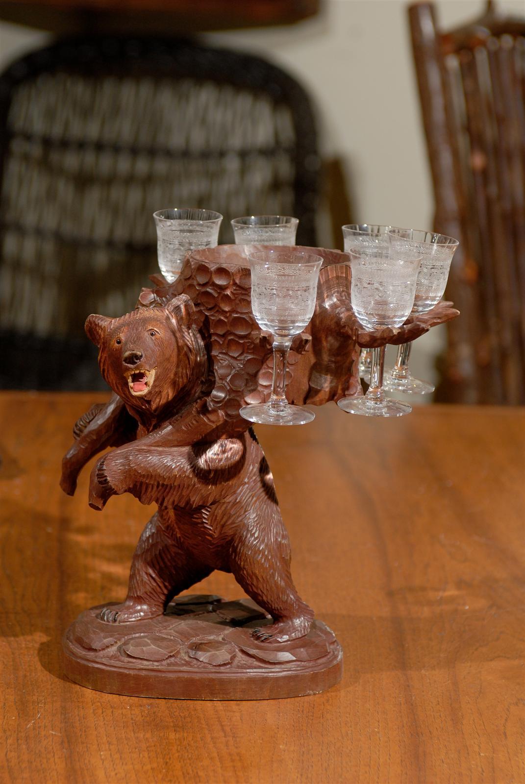 This Black Forest Bear is  supporting a set of etched cordial glasses.  The base is carved to look like carved rocks in relief.  The bear is holding a tree trunk  that is fitted to hold 6 etched glasses.  This is a wonderful example of Black Forest