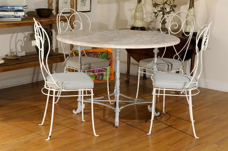 This is a wonderful round table which could be used in many different places and for many different things. The small striped blue, tan and cream fabric on the cushions is in excellent condition This can be used indoors or outdoors. The chairs