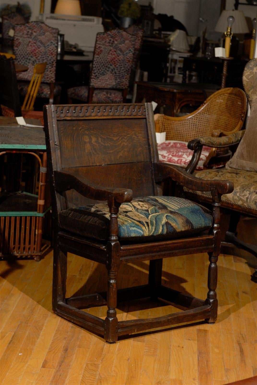 Chairs were very special in the late 17th century. Most people were sitting on joint stools. This one is very sturdy. It is made of oak and has the most amazing patina. All of the wear is in the right places for its age. The braces on the legs and