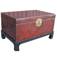 Brown leather trunk on wooden stand