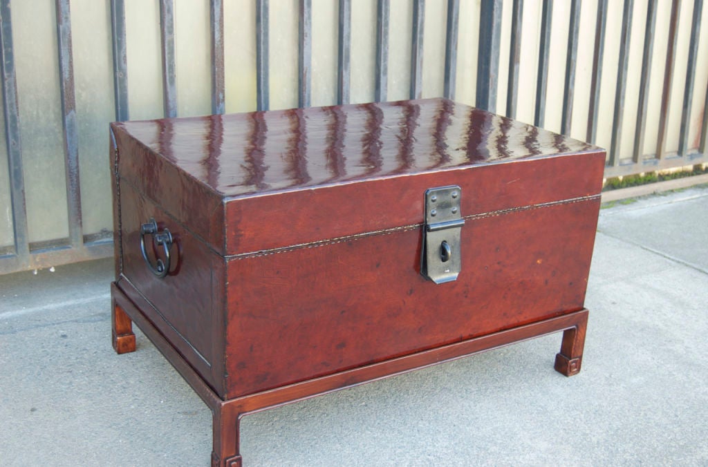 Brown leather trunk on wooden stand