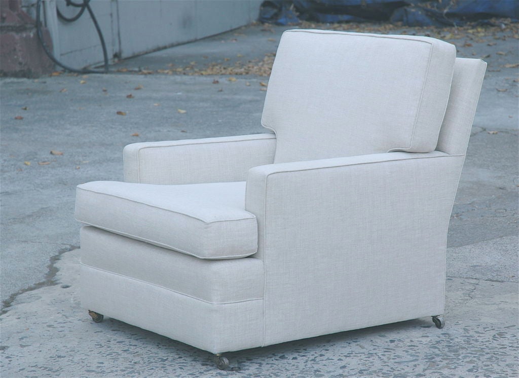 Understated and comfortable Paul Frankl lounge chair covered in backed Calvin white linen with original castors.  Rebuilt springs and top quality fill provides the comfort and durability only the best re-upholstery work can provide.  Much of the