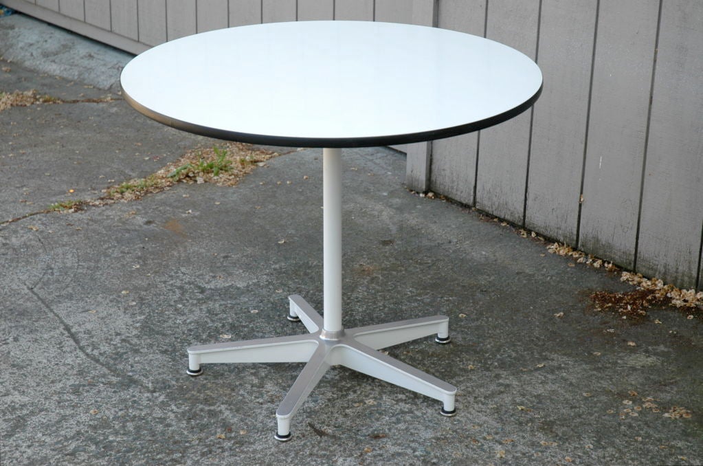 Rare and sexy circular white top dining table by Charles Eames for Herman Miller.  Out-of-production five star base 670 base in unusual white with matching white stem and five rubber-insulated adjustable chrome glides.  Glossy vintage white Micata