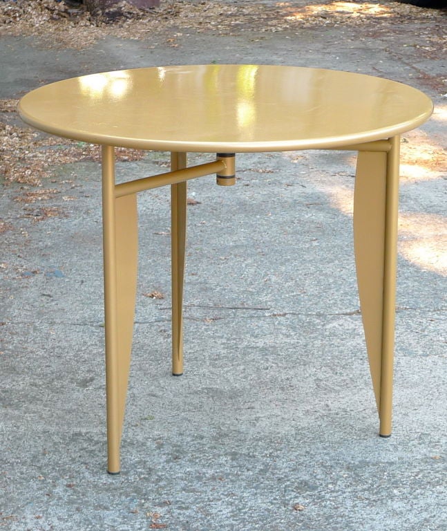 Gold and-dare I say-bold metal café table with winged legs.  High-tech/Regency as only Philippe Starck, at his creative peak, could forge.  
Also produced in other colors, this is the iconic gold version.  As Starck, himself, put it, 