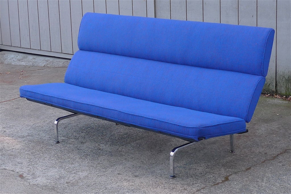 Charles Eames “Sofa Compact,” design for Herman Miller, 1954.
Unique folding sofa for ease of transport.  Seat and back recovered in blue fabric atop extremely sturdy, all-original enameled steel and chrome base.
Reupholstered in vintage Girard