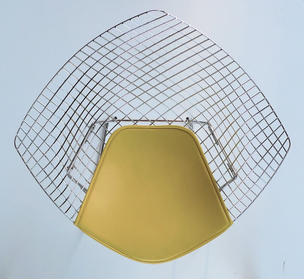Current production example of 1952 Harry Bertoia design for Knoll.
Free form chair with vibrant yellow seat cover on diamond-shaped chrome wire frame.
Visionary form courtesy of Bertoia's sculptural vision but tamed by Richard Schultz who assisted