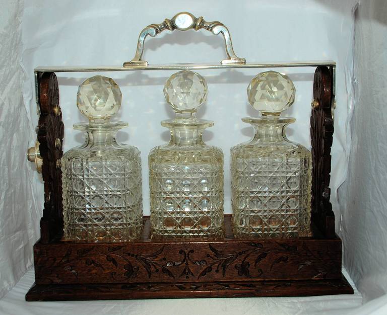 Antique English Three Crystal Bottle Decanter encased in Carved Oak and Sheffield Silver-plate.