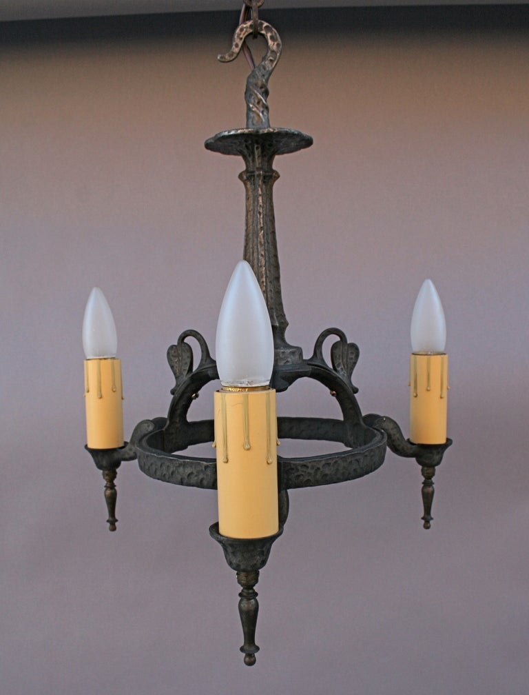 Lovely little chandelier c. 1920's with hammered texture, rich dark pewter-colored patina, and wonderful detail such as the tiny stylized leaves and curving twists of the suspended finial at center.
