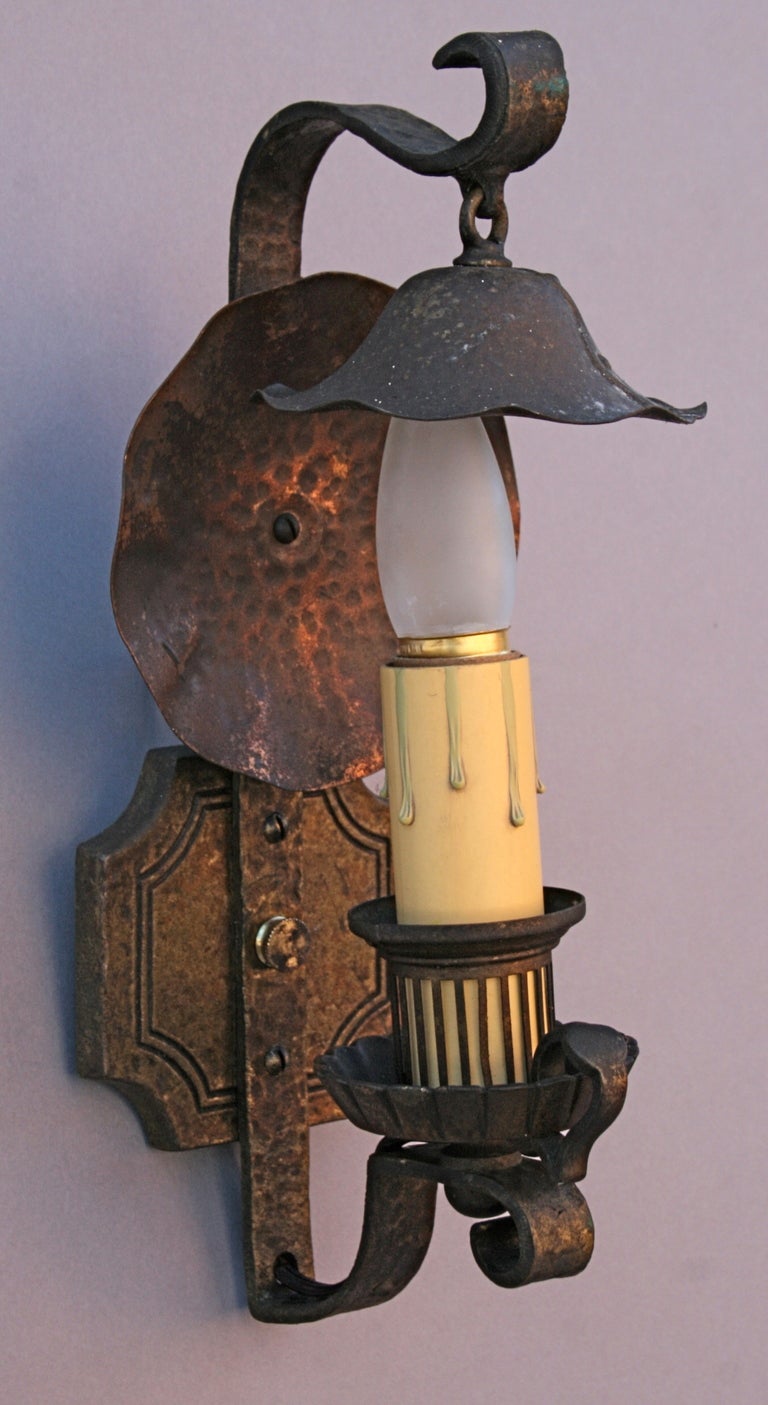 Exceptionally well-crafted single-light sconces of brass and hammered copper, with original patina to finish, decorative smoke bells and hammered reflector plates; signed Lion Electric Manufacturing Co. circa 1920's