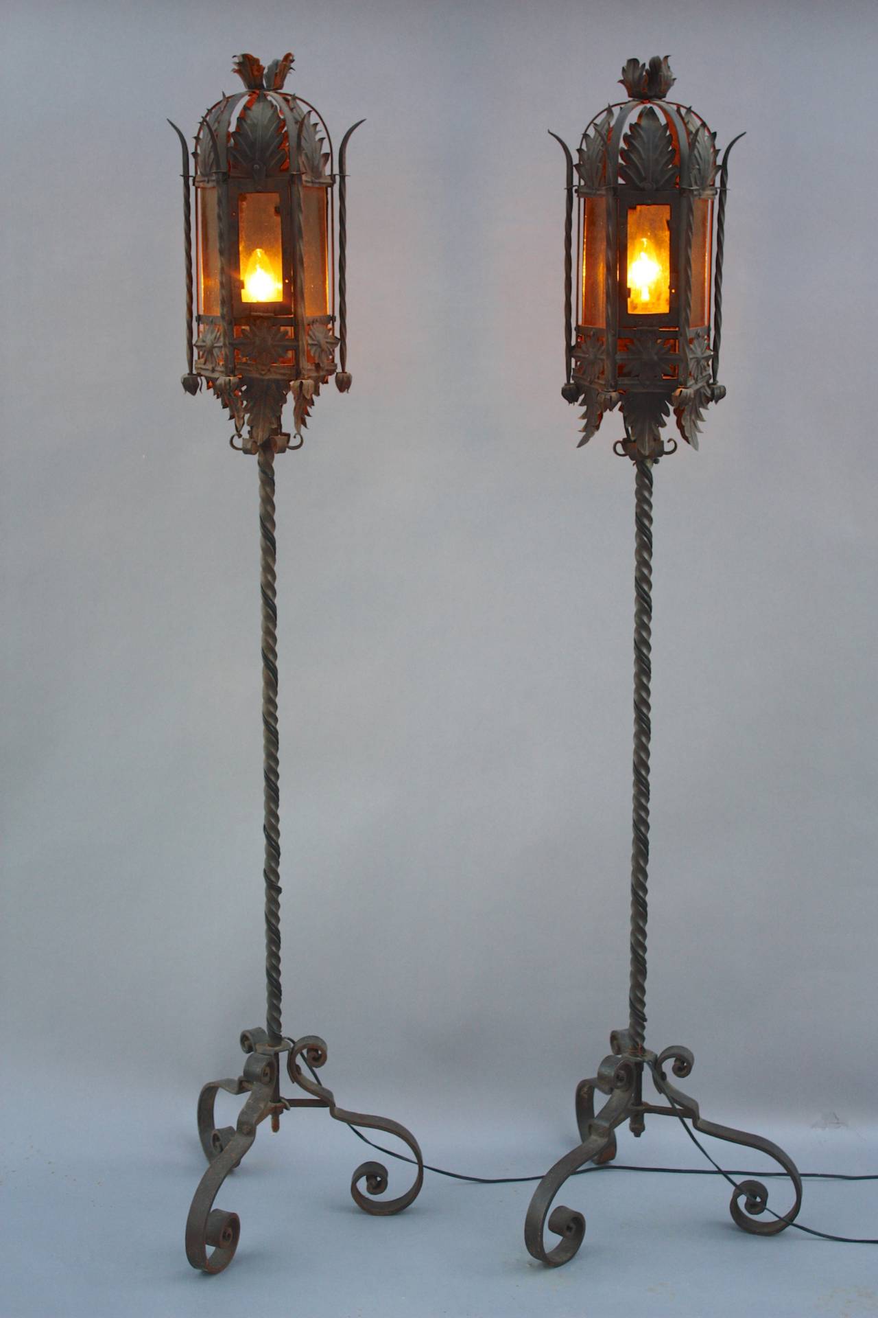 Torchieres with wrought iron base and original glass, circa 1920s. Each measures 66.5