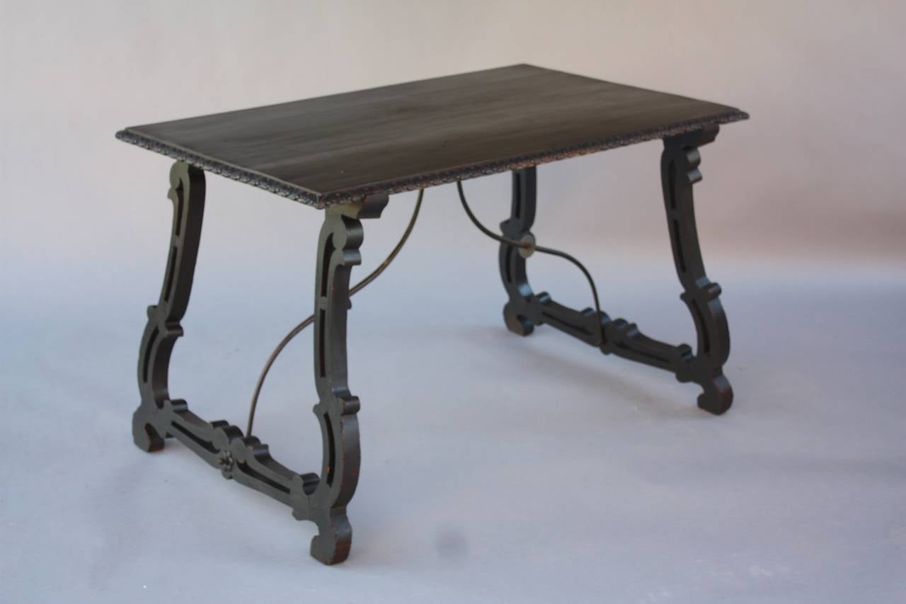Fantastic Spanish walnut table with splayed lyre leg and iron trestle. Nicely carved border with cut-out on the legs. 

Dimension: 50.5