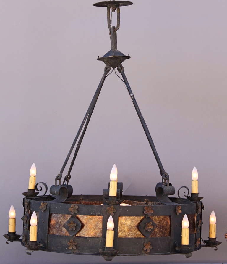 Beautiful and dramatic is this wrought iron chandelier c. 1920's - '30's, illuminated by twelve candle-style lights, as well as 8 lights in the center of the 