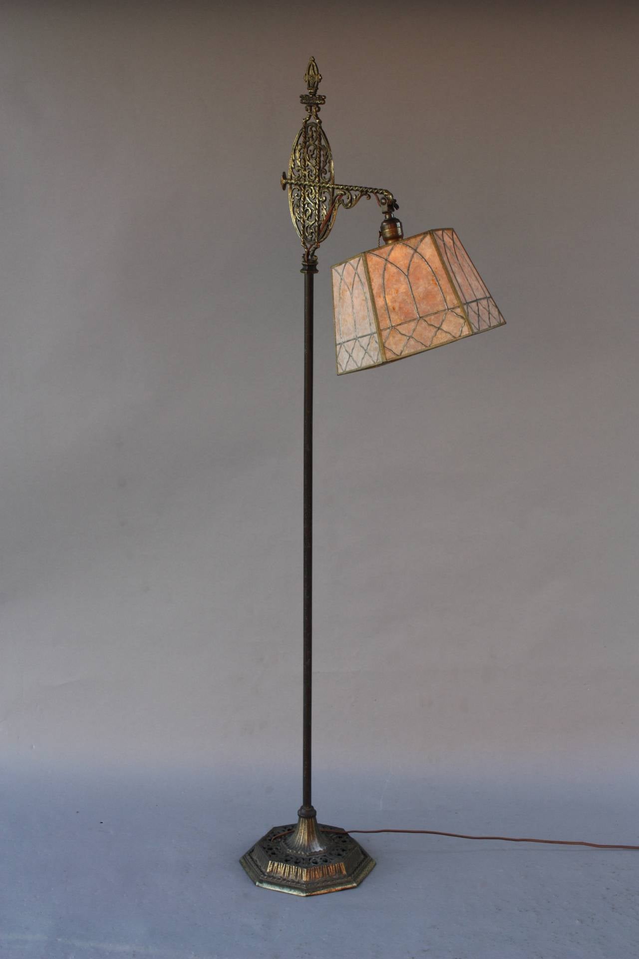Very nice mica floor lamp with adjustable mica shade. Circa 1920's. The casting on the base is very intricate with leaf design and the shade has the classic motif of arches. Would fit in Tudor and Spanish Revival Decor.