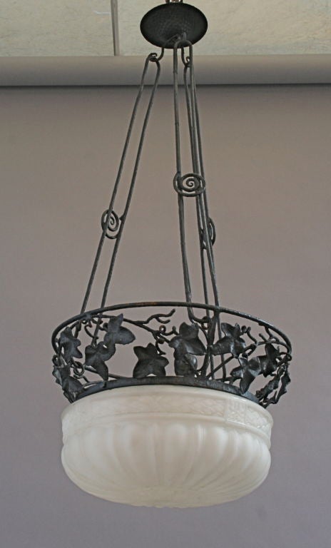 Beautiful 1920's wrought iron chandelier with glass insert.  Beautiful organic use of iron rendering a beautiful iron foliage.  European Deco
