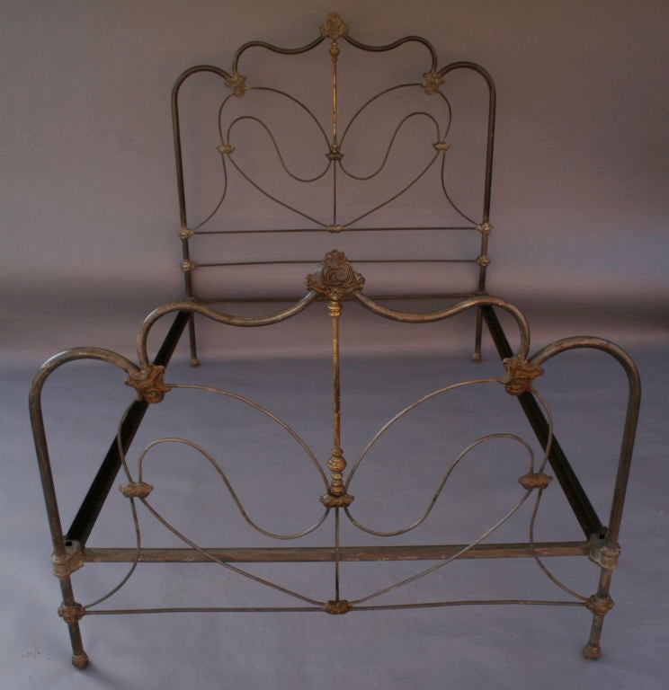 Gracefully curving scrolls of iron are joined and accented by decorative cast and turned brass elements in this lovely and elegant double/full bed frame