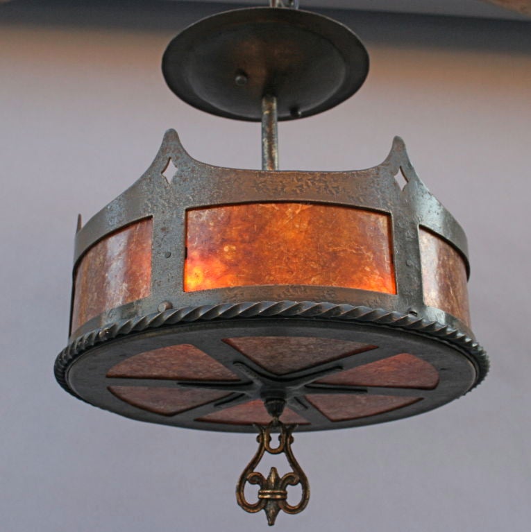 Beautifully designed ceiling fixture in hard-to-find scale of hammered iron with cast brass details and lined in amber mica; open top area allows for light from three concealed bulbs to bounce off the ceiling for additional illumination; perfect for