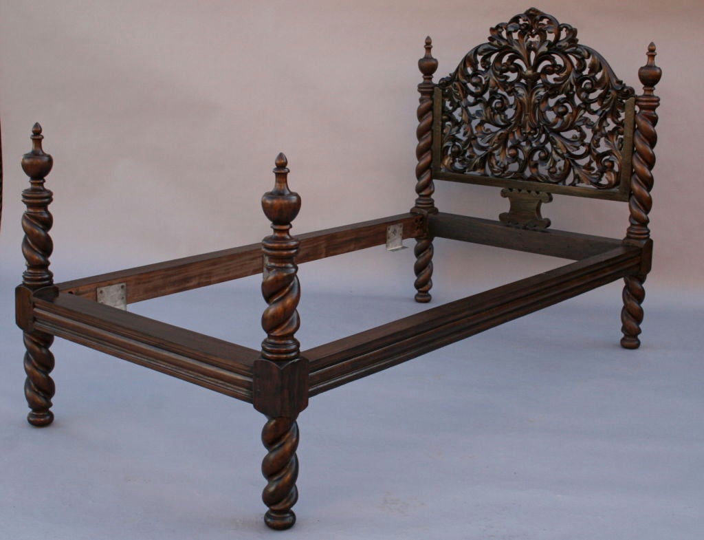 Ornately carved pair of twin mahogany beds with thickly turned post legs; could be modified for use together as a king bed frame; very striking and dramatic and expertly crafted.