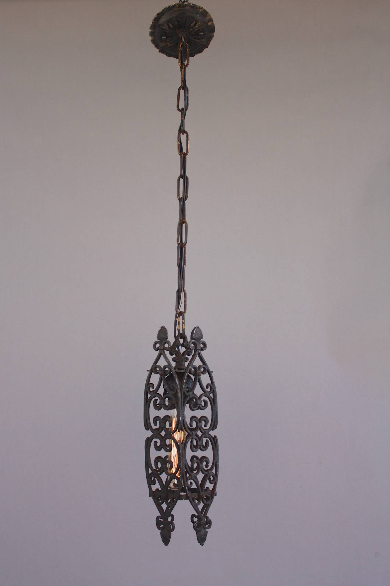 Circa 1920's narrow pendant with scroll motif. The body of the fixture is 15.5