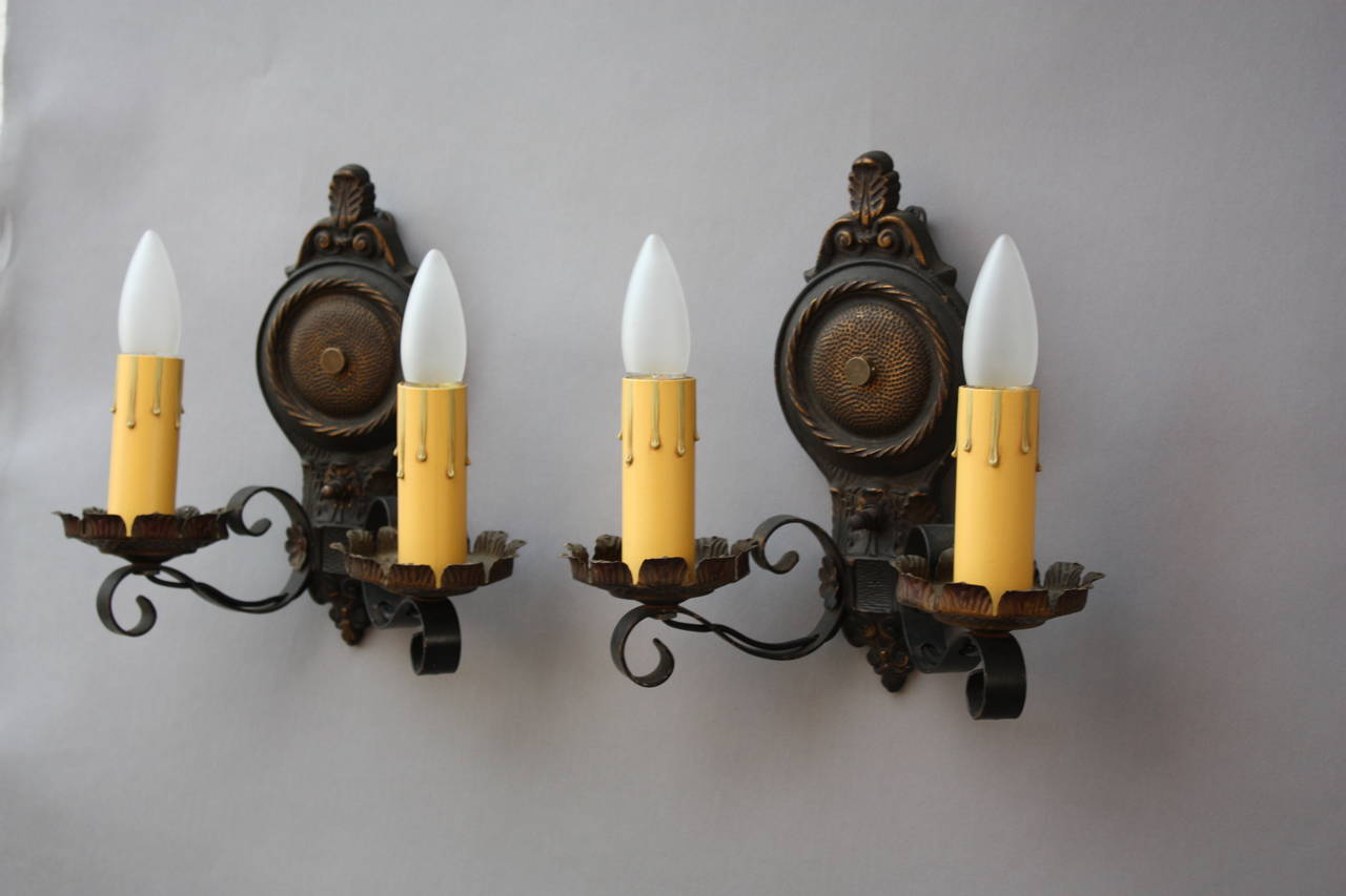 Pair of cast and wrought iron sconces, c. 1920's. Original finish. Measures 10