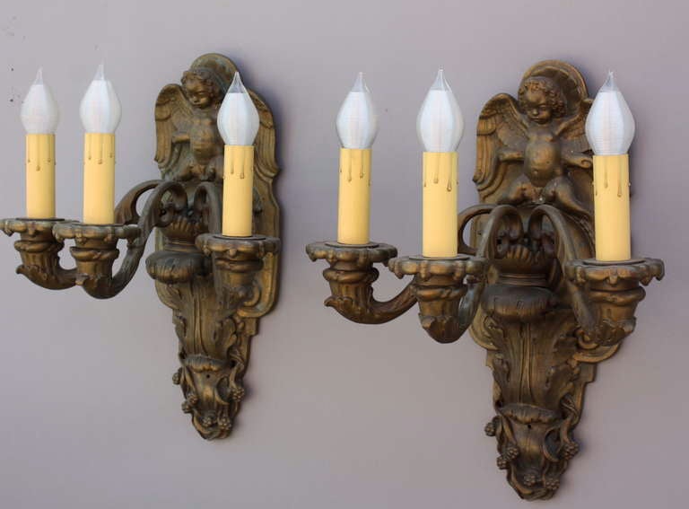 These classical wall sconces are from the 1920's and are Italian in style. Winged angels and acanthus leaves are finely cast in hravy bronze, with beautiful original patina.