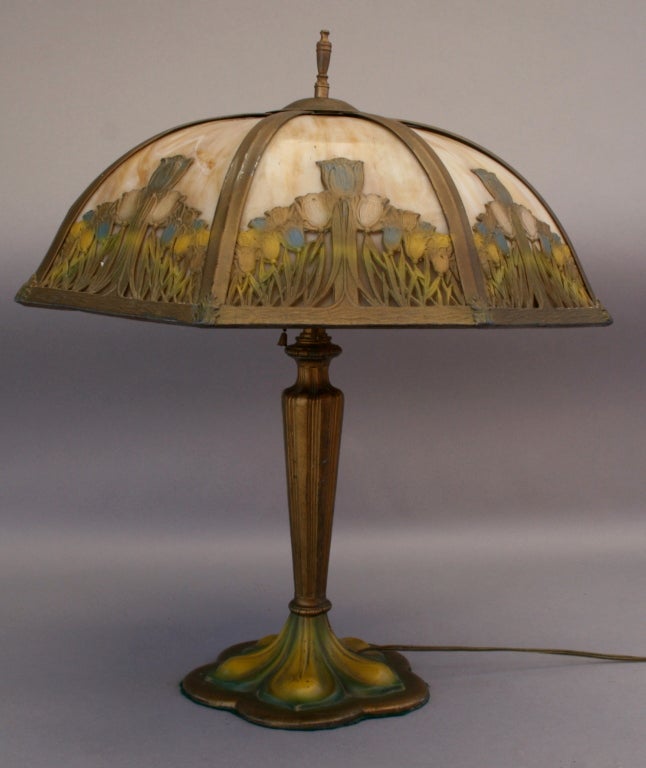 Circa 1910 slag glass lamp with cheerful tulip motif. Original polychrome finish.The shade has eight glass panels.