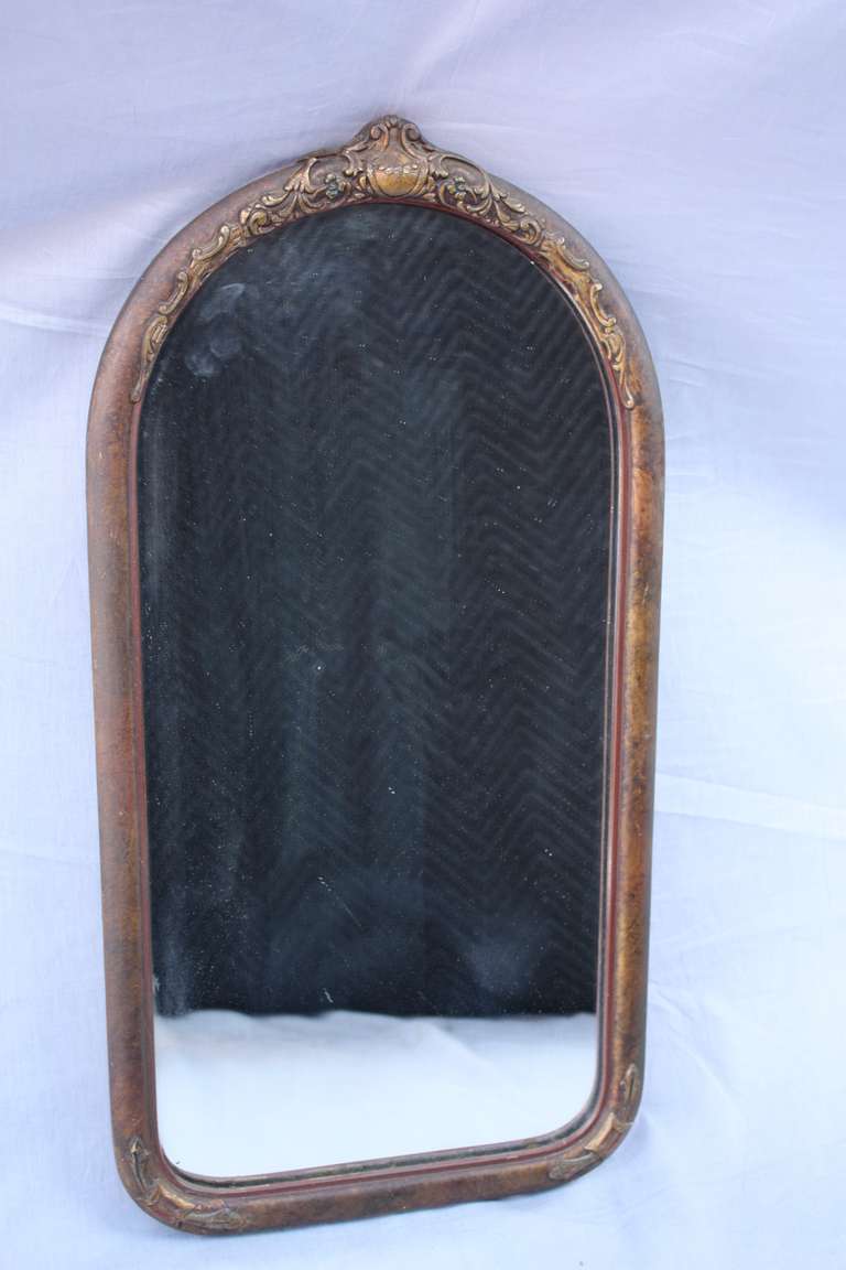 Circa 1920's mirror with original finish. Crest motif. 26 3/8