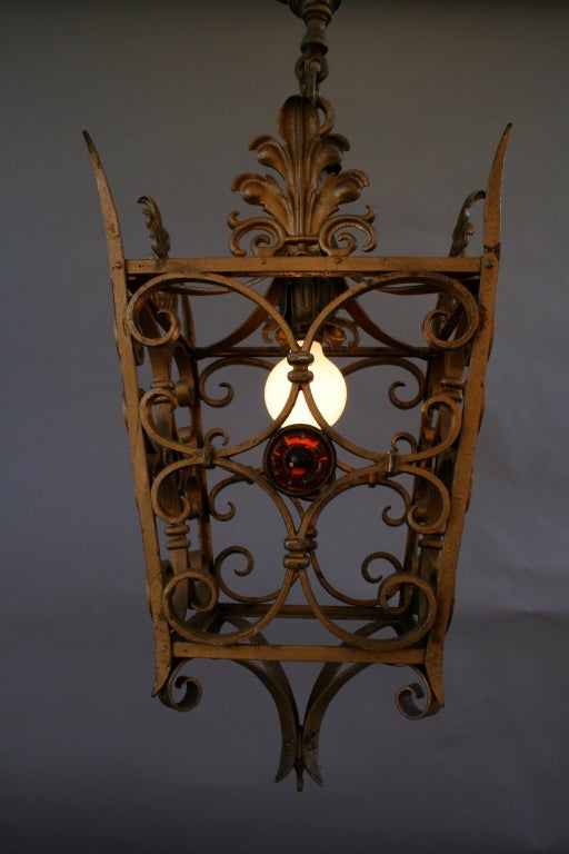 Hard to find scale perfect for hallways and covered outdoor areas. Beautiful wrought iron construction with multi-colored molded glass roundels. All original finish; circa 1920's