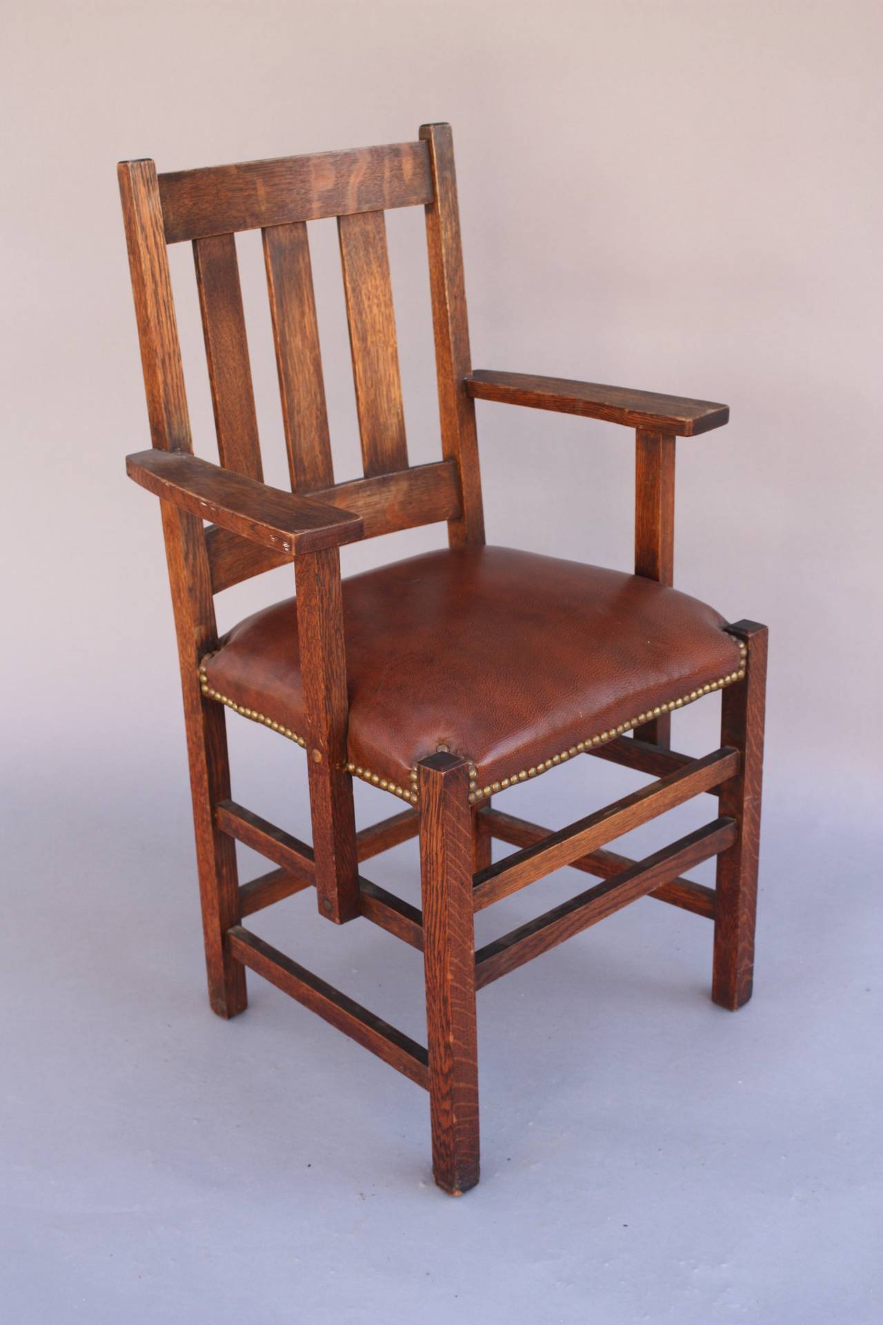 Circa 1910 set of 5 side chairs and one armchairs. Signed. Quartersawn oak and leather seats.  armchair measures 23.75