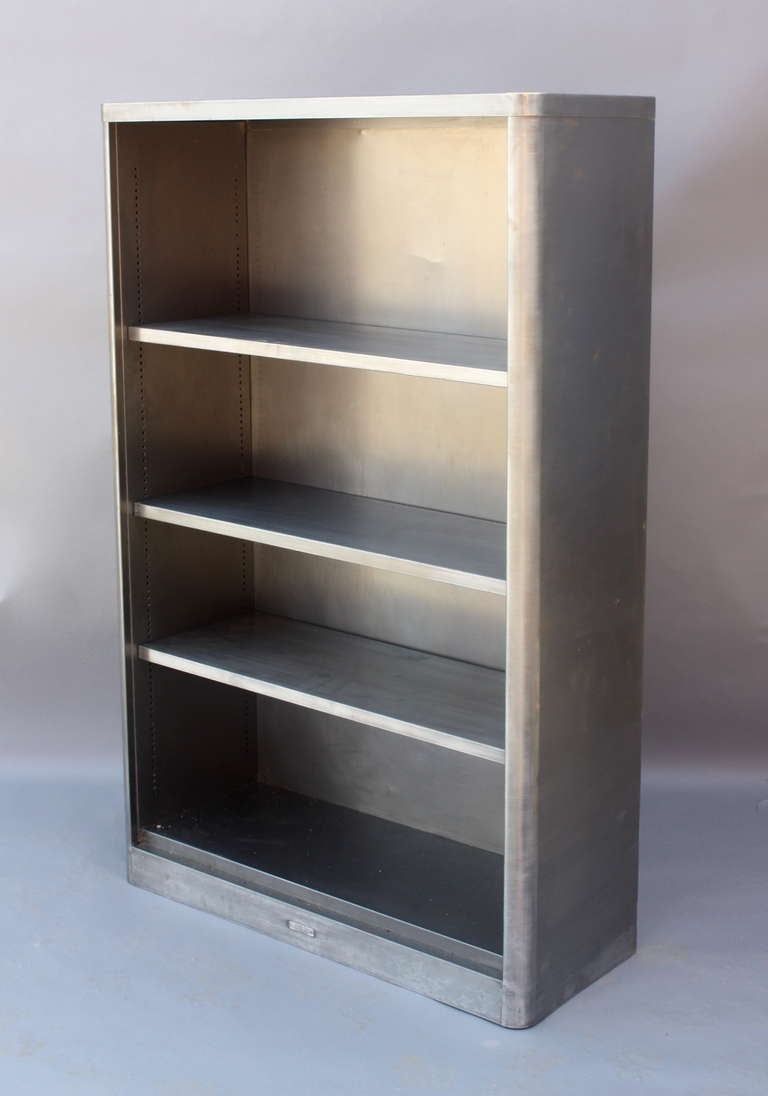 Vintage stainless steel bookcase with three adjustable shelves.