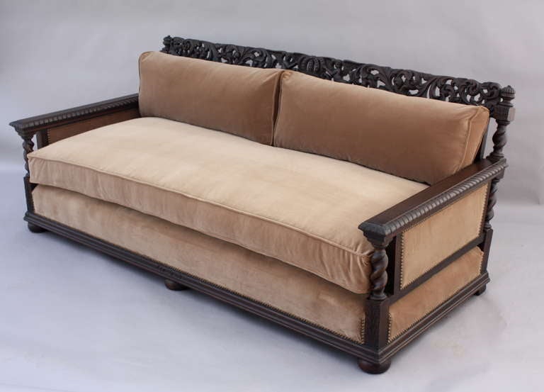 Hand carved walnut sofa with ornately carved frame. This has been newly reupholstered in velvet. Nice, deep seat and very comfortable. Vintage frame with all new upholstery; down and feather filled cushions, belgian velvet with brass nailhead trim.