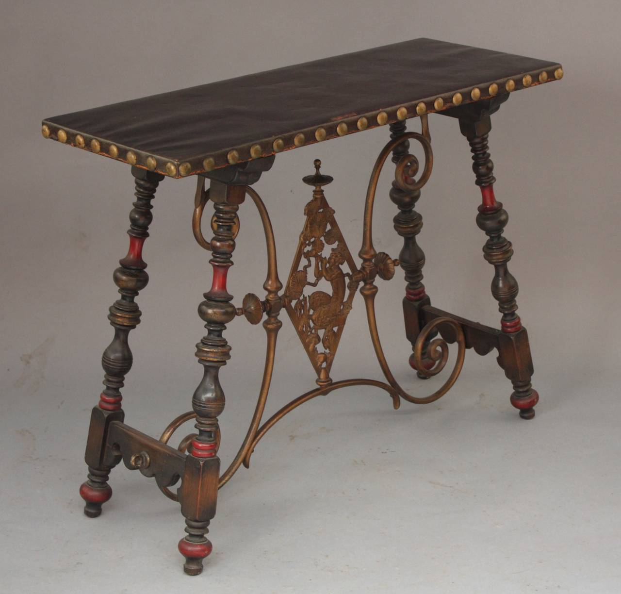 Console, circa 1920s in the manner of Oscar Bach. Side leather top table with a satyr decoration across the stretcher. It has the original polychrome on the turned legs with a leather leather top. It measures 16