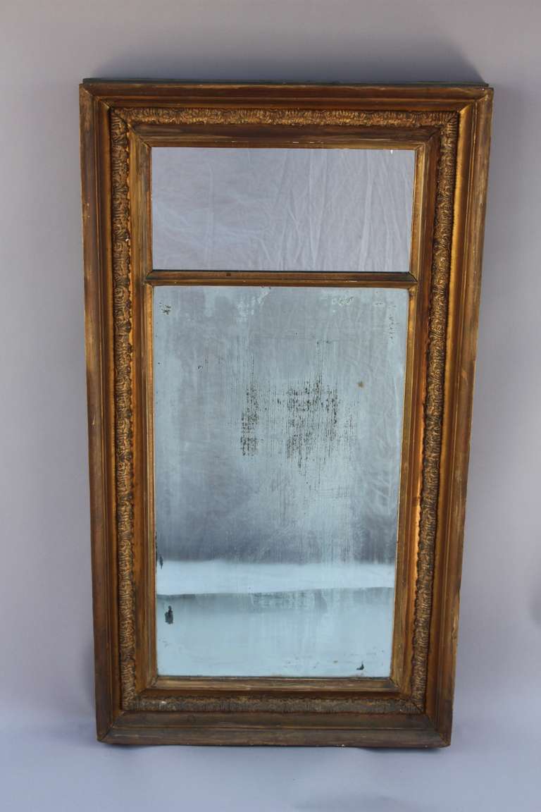 Late 19th century mirror with original glass in the lower portion with some loss of silver in mirror. New mirror in the upper portion. Original finish. American.