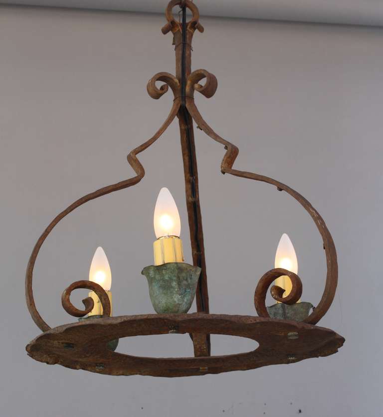 Circa 1920's three light chandelier with original patina. Iron construction and copper cups. Would work wonderfully in adobe style home or with Monterey furniture. Body of fixture is 21