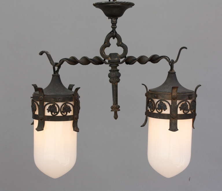 Wonderful and unusual fixture with pretty ironwork silhouetted over two original white glass pendants; measures approx. 25