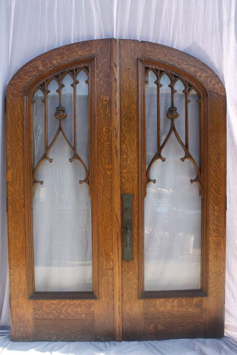 Impressive of oak and glass front doors. Circa 1910. Very nice carving. Acorn motif. The hardware beautifully represents the period. 95.5