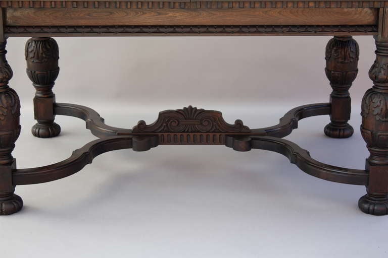 Dining table c. 1920's with elaborately carved trestle and two large leaves which unfold in the center to allow for expansion to over 8'; closed measures approx. 41 1/2