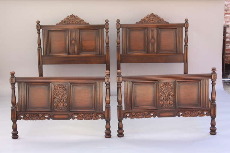 Charming pair of twin/single beds with stylized floral carving c. 1920's; rich original finish highlights details; sold as pair