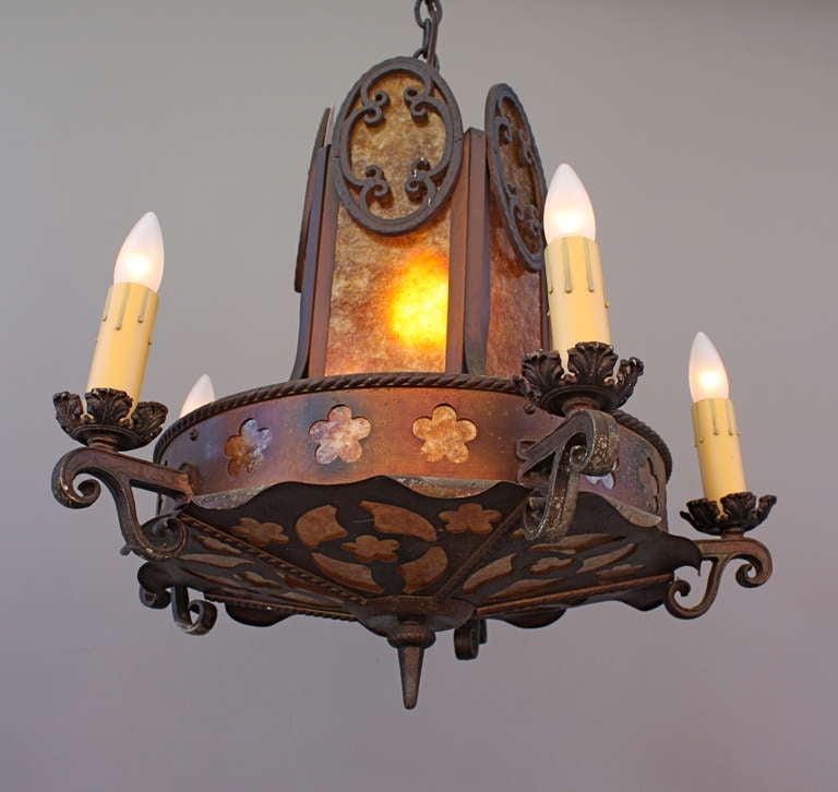 Beautiful unique fixture c. 1920's give lots of light via five candle-style lights about the circumference, paired with the romantic glow of mica behind silhouettes of cut metalwork;  measure approx. 21.25