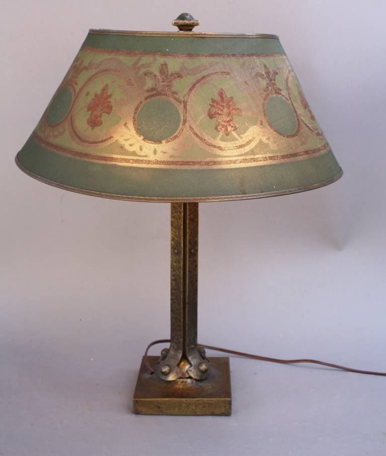 Lamp with beautiful hammered base and period metal mesh shade. It provides a beautiful light. Some wear on the shade, circa 1920s.