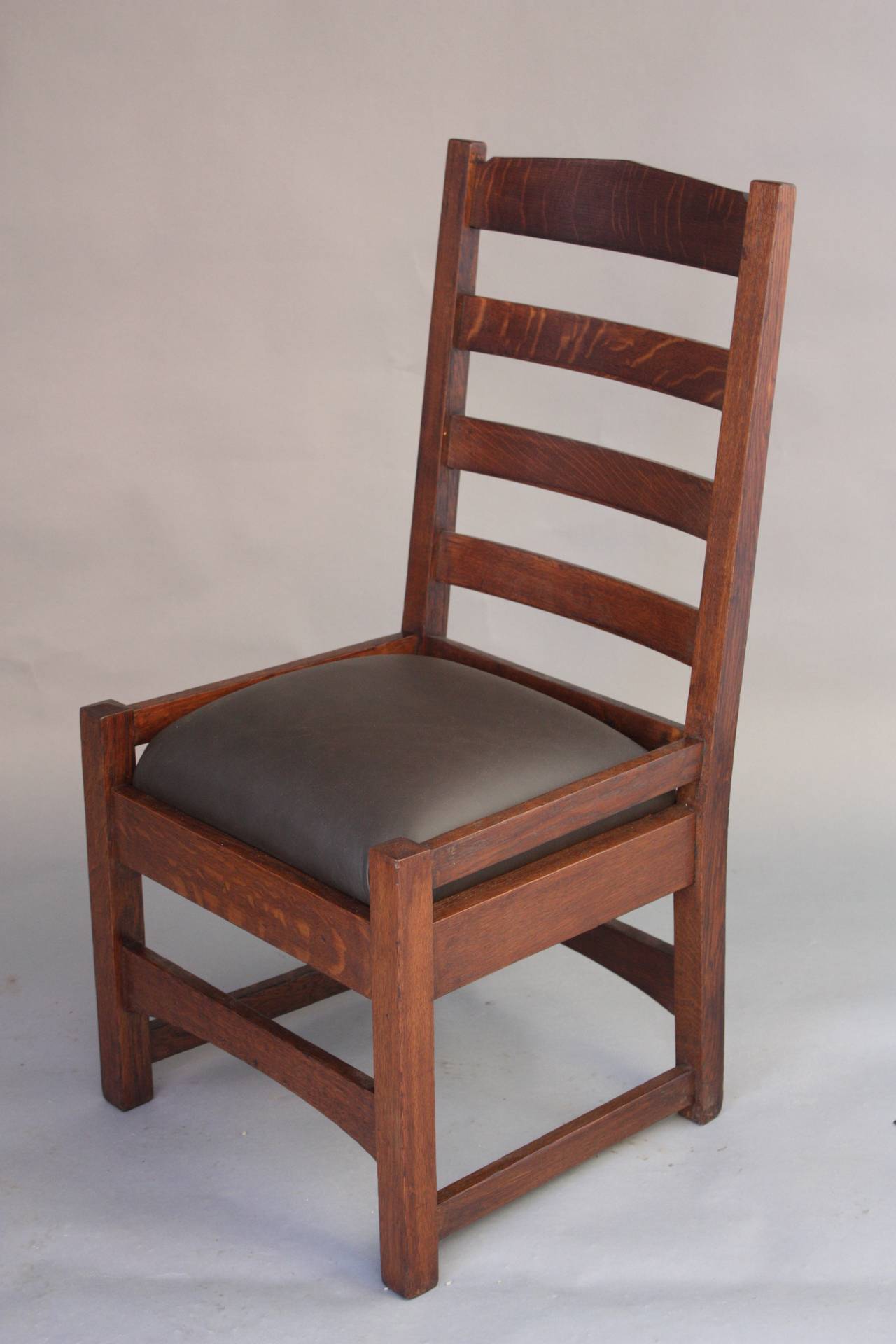 Classic arts and crafts side chair with ladder back. Beautiful quarter sawn oak. New dark leather upholstery 36.75