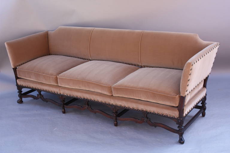  This handsome sofa is a custom replica of a 1920s sofa we have. The frame is carved walnut and the fabric is Belgium velvet.