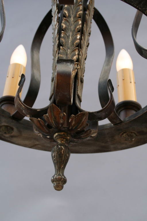 Small but stately Spanish Revival chandelier. Simple overall design with nice detailing.