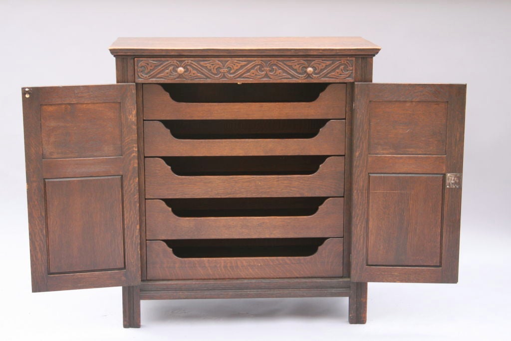 Finely carved oak and marquetry cabinet. Signed by Robert Irwin Company from Grand Rapids. It features five line drawers.